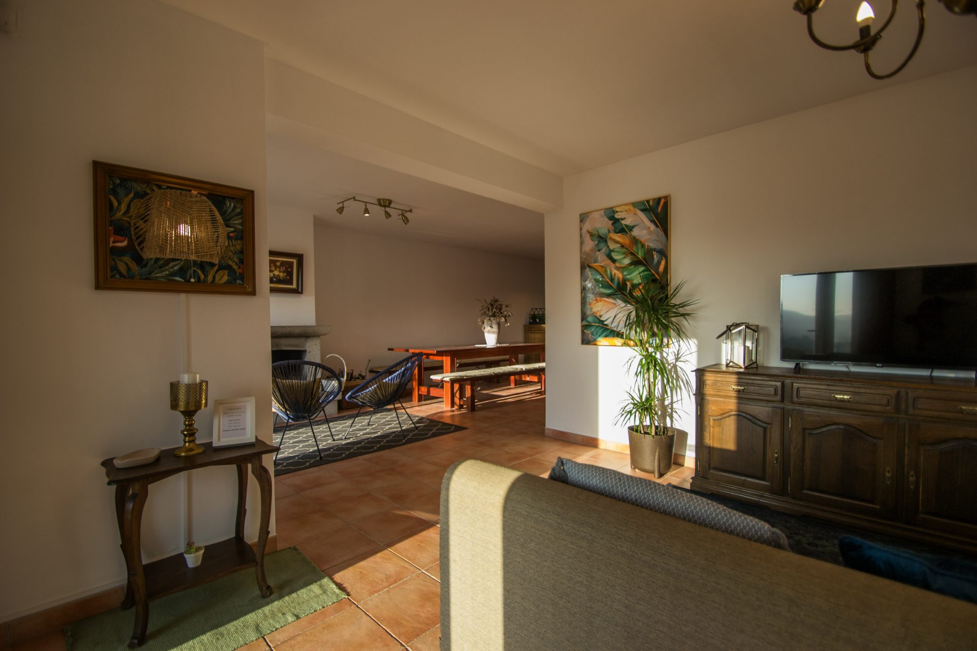 Sala de estar com televisão e sala de jantar ao fundo