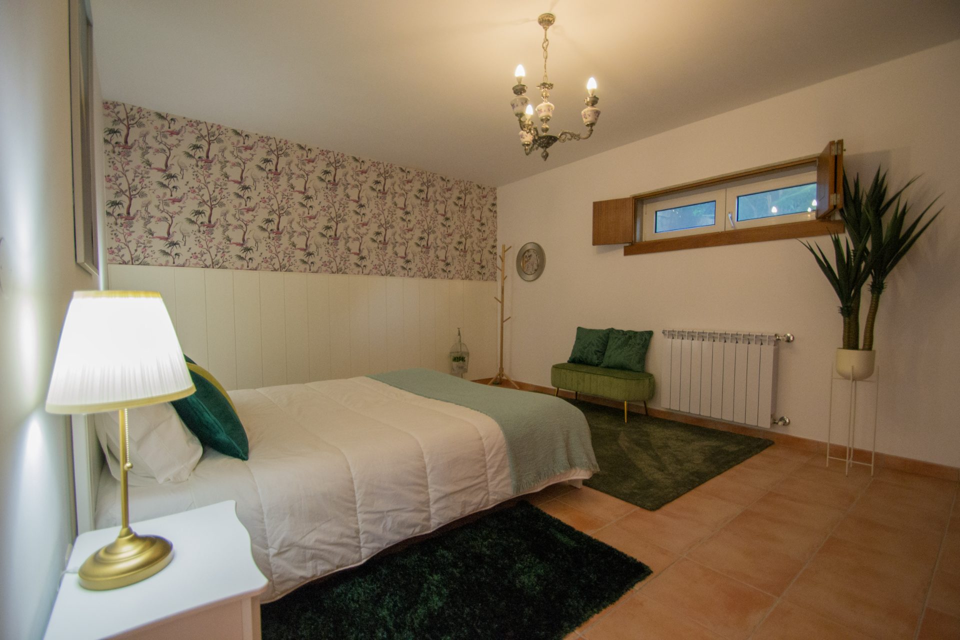 Quarto principal com papel de parede floral e banco verde