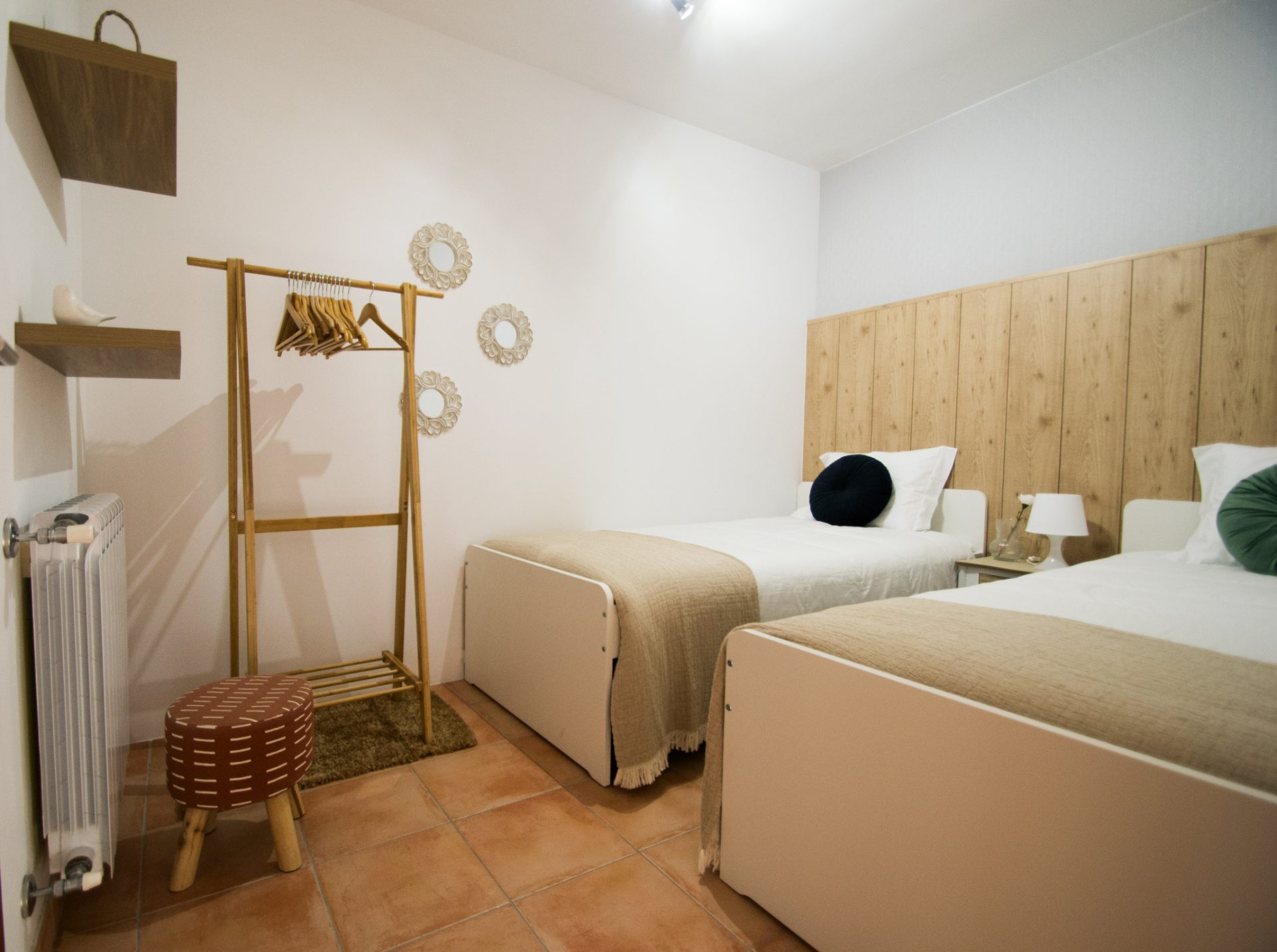 Quarto duplo com bengaleiro de madeira e espelhos