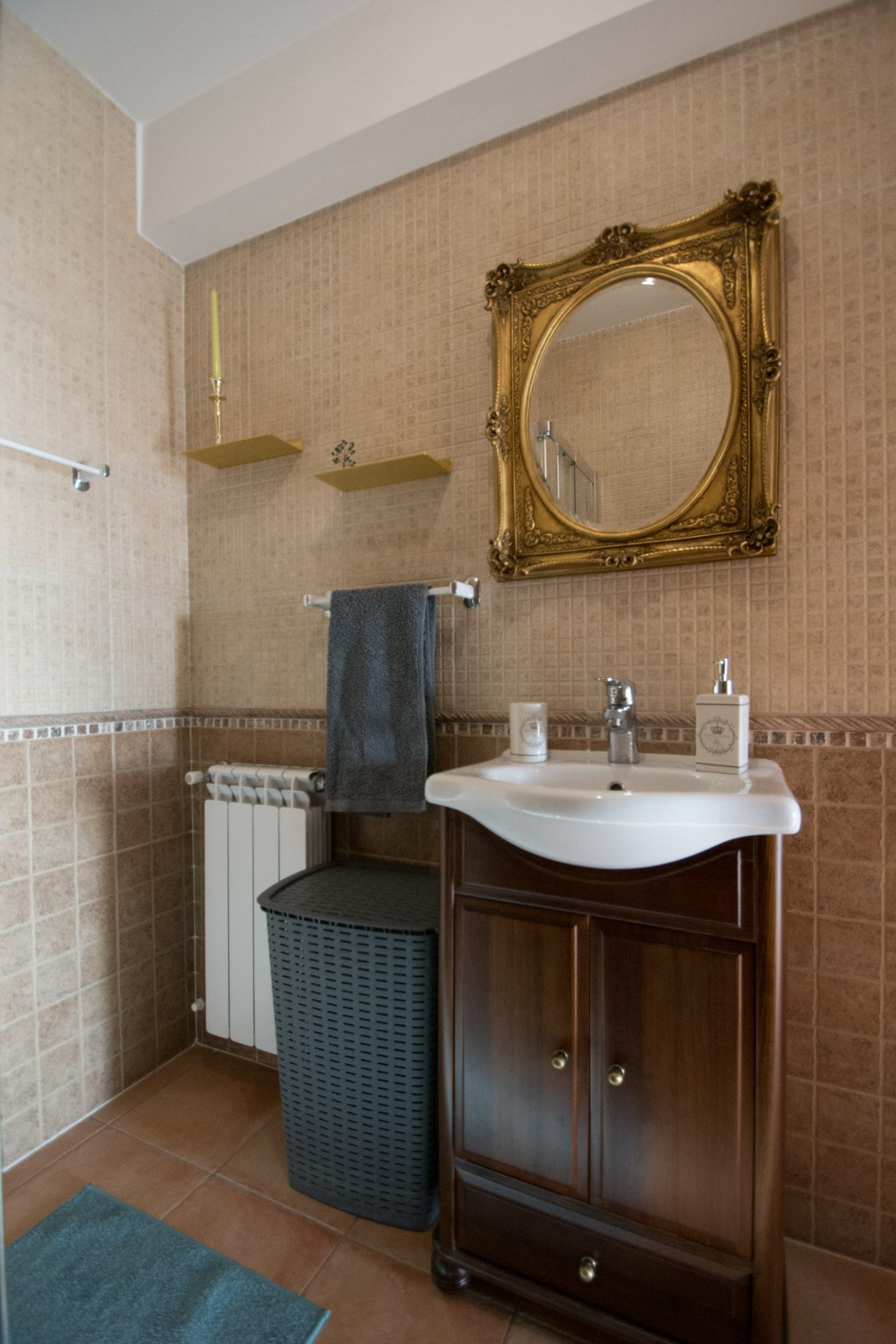 Casa de banho com espelho dourado e lavatório